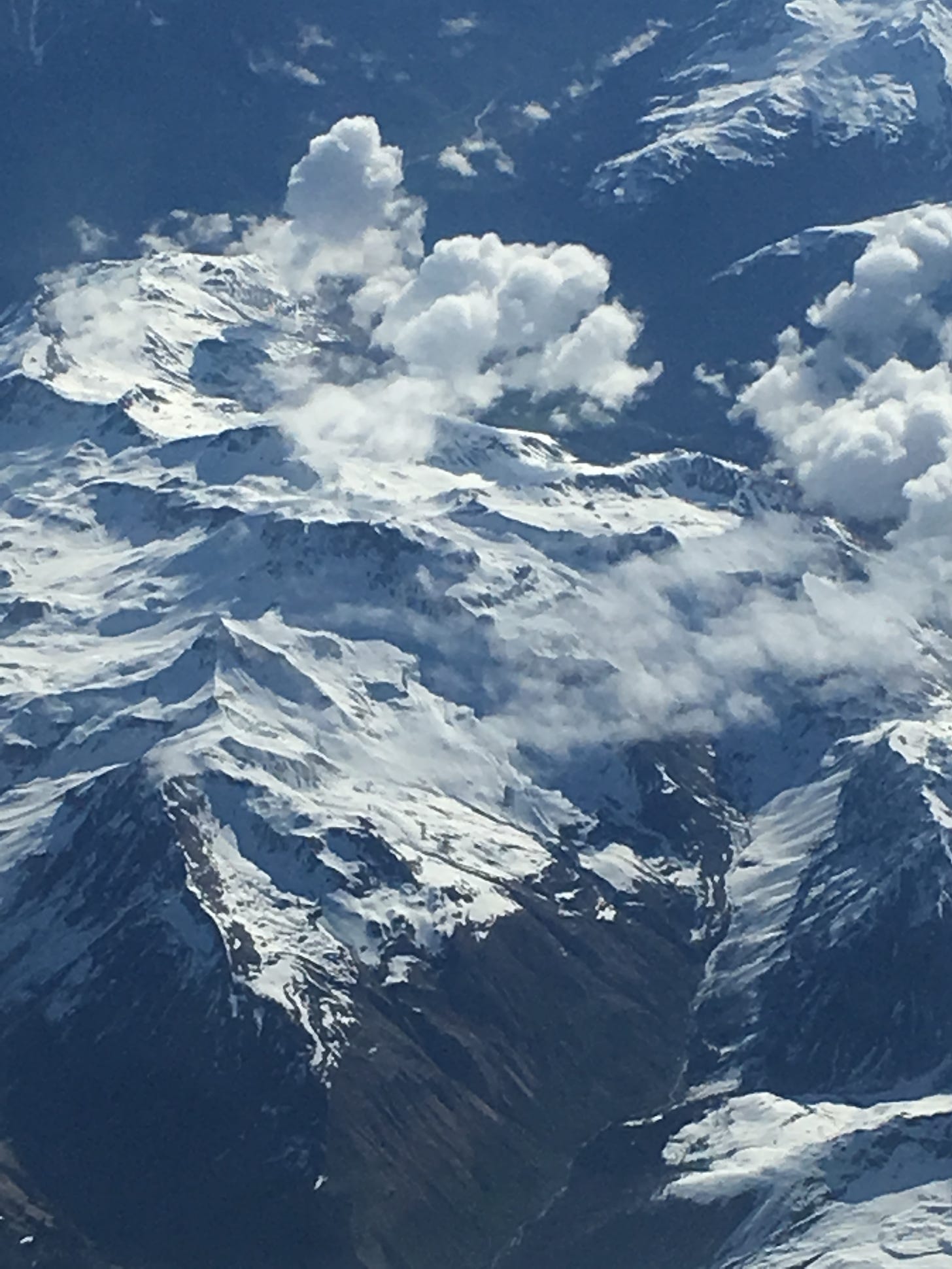 A view of the Andes, covered in snow and wreathed in clouds.