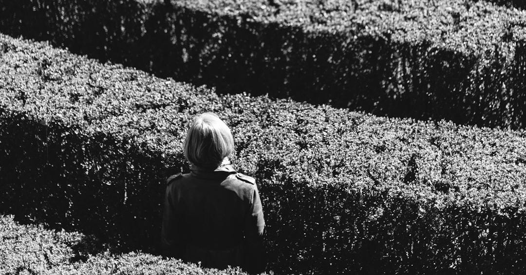 grayscale photo of person inside the plant formation