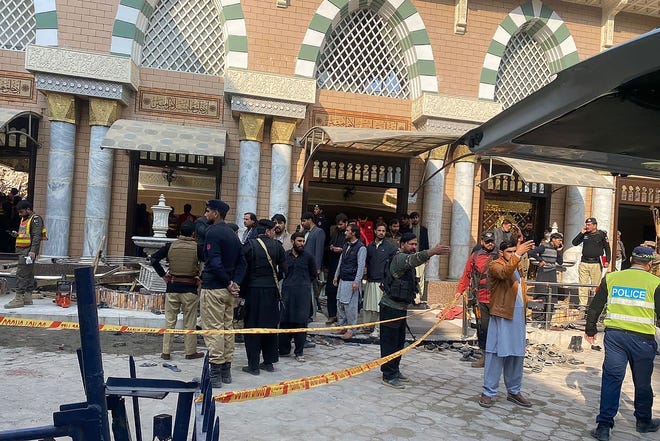 Security personnel cordon off the site of a mosque blast inside the police headquarters in Peshawar on January 30, 2023.
