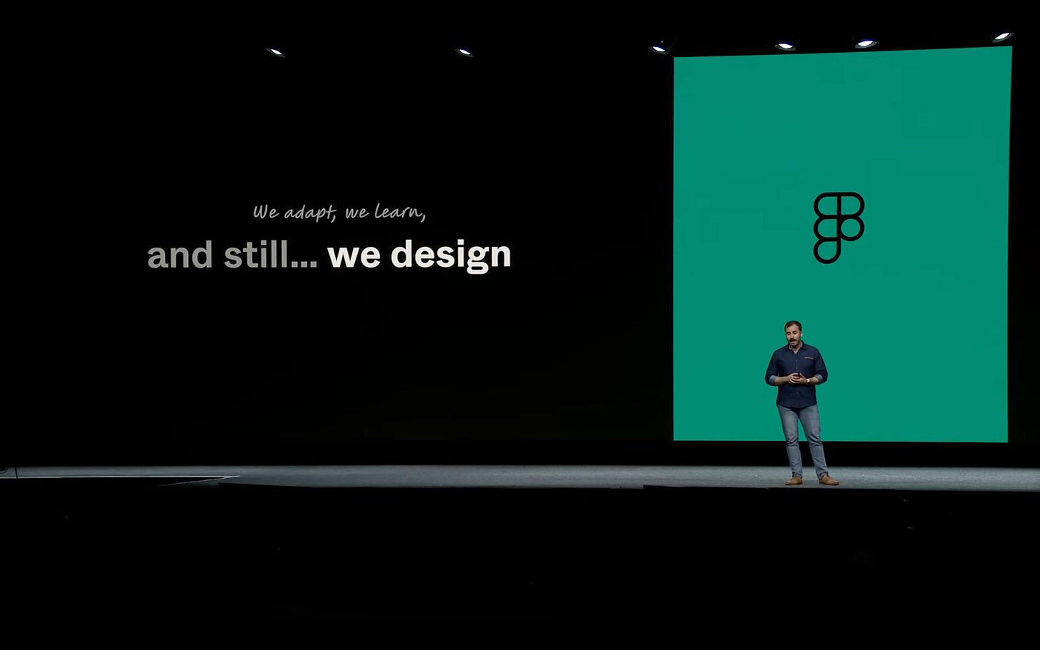 Photo of Noah Levin on the stage of Config 2023 with a deck slide that says ""We adapt, we learn, and still… we design”" 