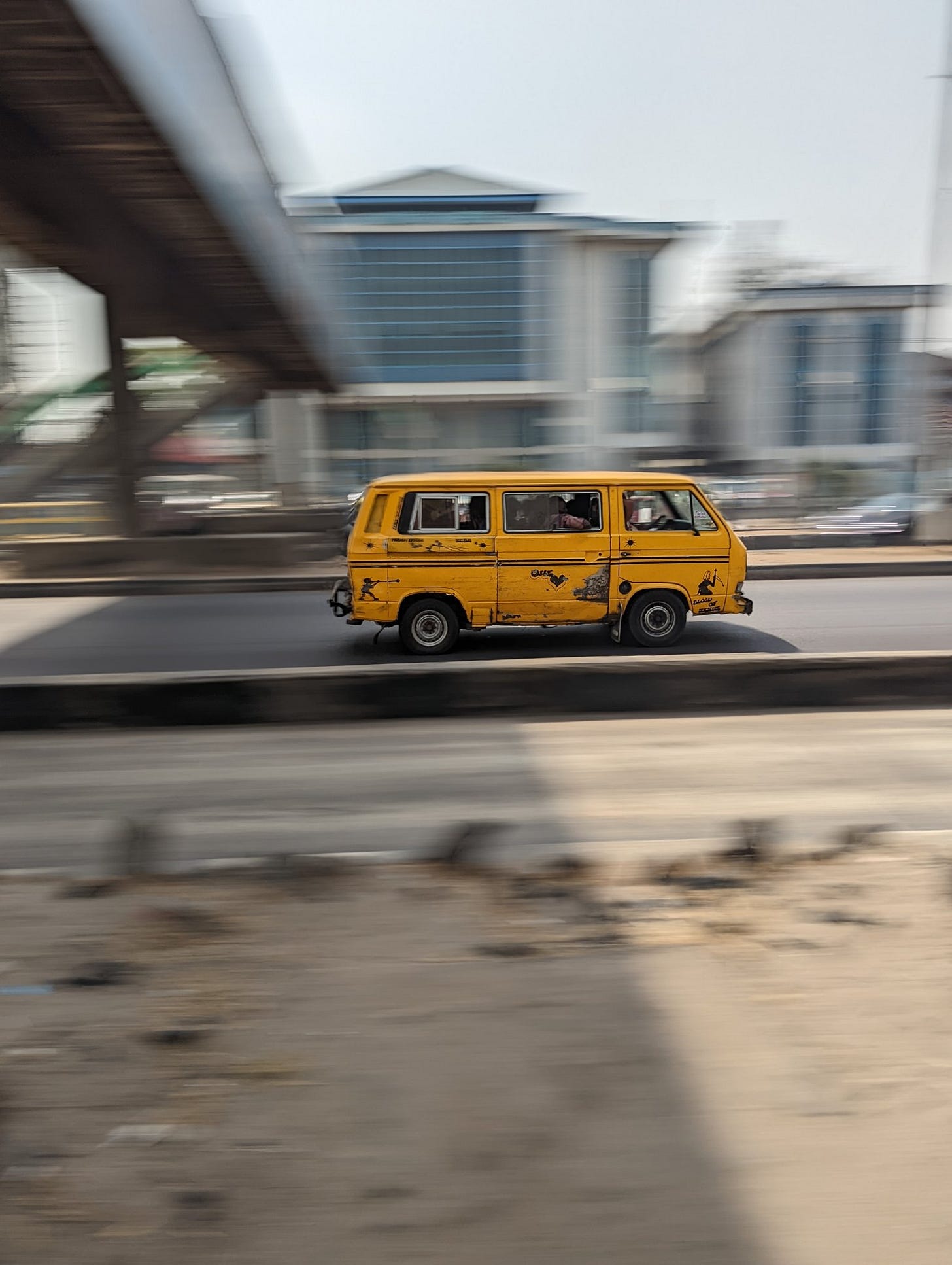 A photo of a yellow bus [known as danfo] on the express