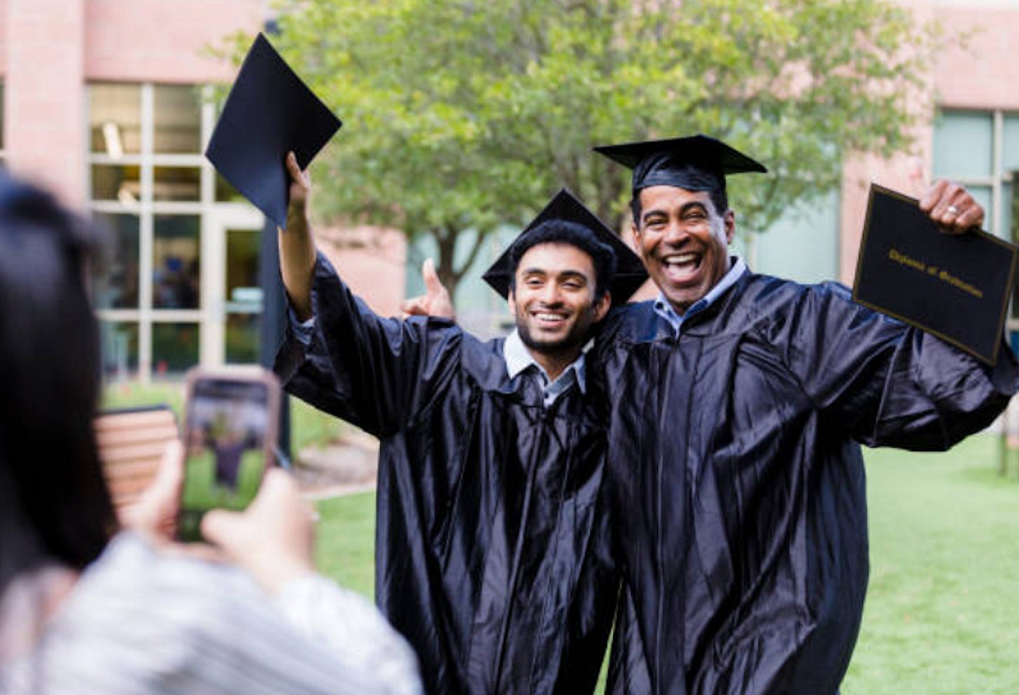 two black graduates in graduation gowns