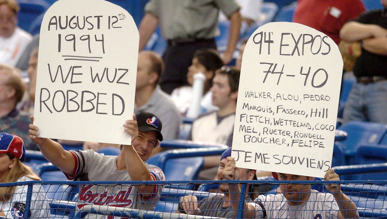 Fans hold signs protesting the 1994 major league baseball strike