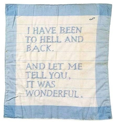 A pale blue and white fabric square, stitched with the words: “I HAVE BEEN TO HELL AND BACK. AND LET ME TELL YOU, IT WAS WONDERFUL.” The text is hand-sewn in soft blue thread. An artwork by Louise Bourgeois.