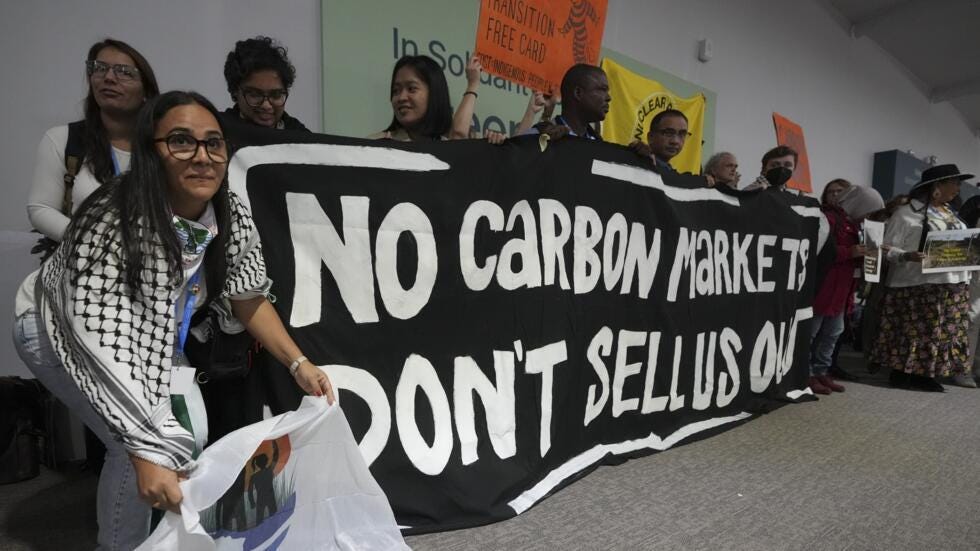 Demonstrators hold a sign at the COP29 UN Climate Summit, 14 November 2024, in Baku, Azerbaijan.