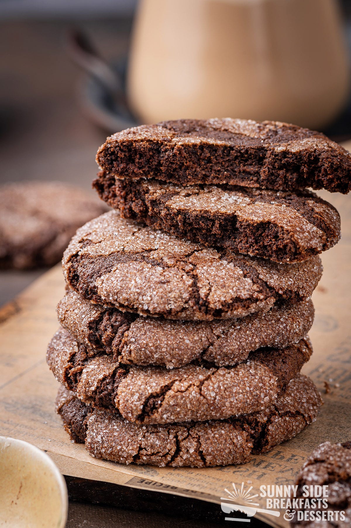 Stack of five chocolate cookies stacked, the top one broken in half.