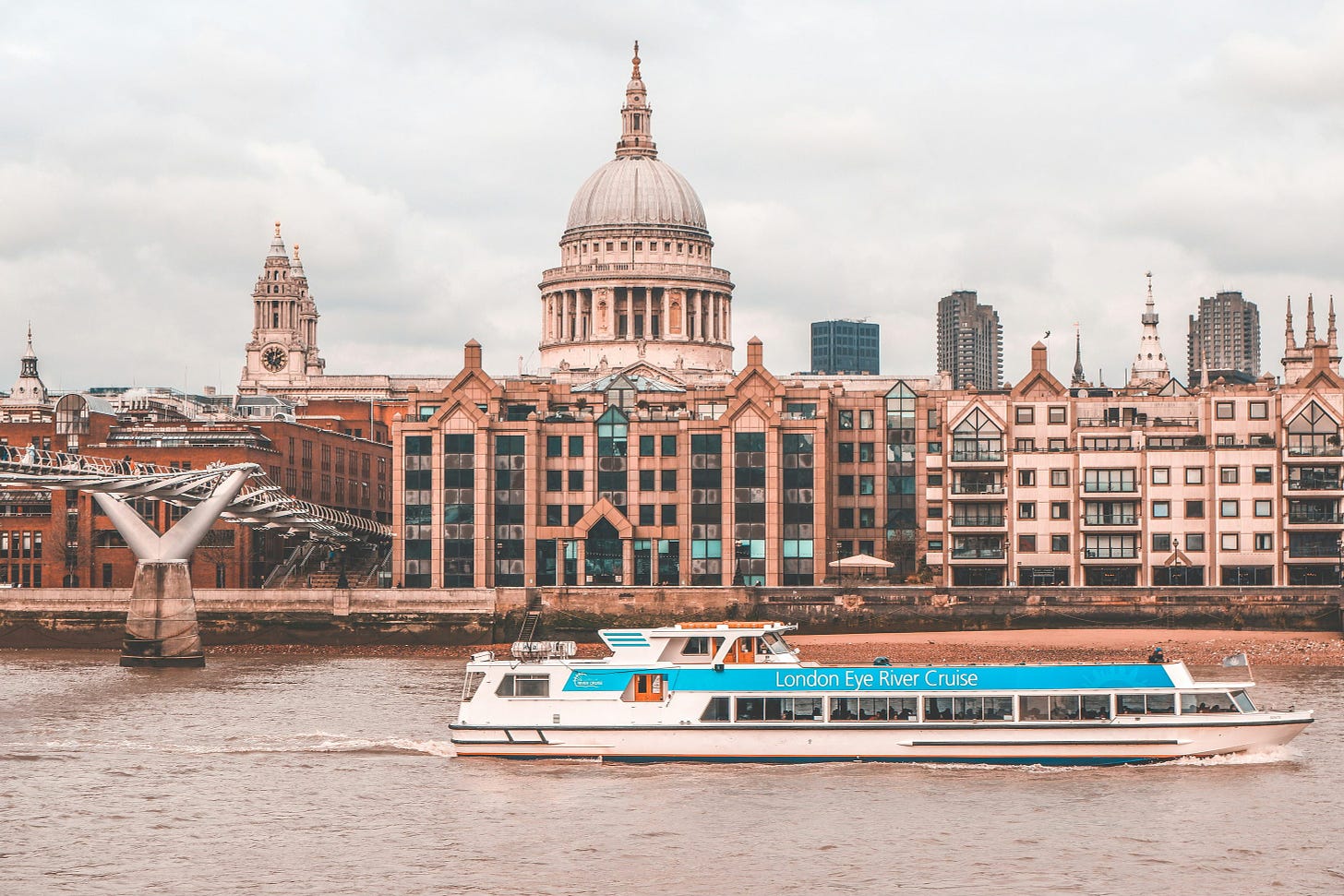 A boat sailing across the Thames in front of St. Paul's cathedral