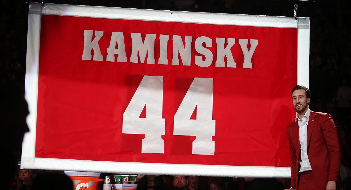 Former Wisconsin Badgers forward Frank Kaminsky stands by the banner commemorating his number (44) retirement at the Kohl Center