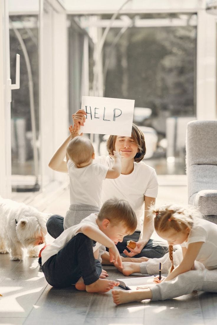 This may contain: a group of children sitting on the floor with a sign that says help in front of them