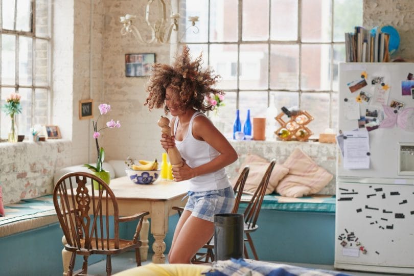 Happy woman dancing in well-lit kitchen