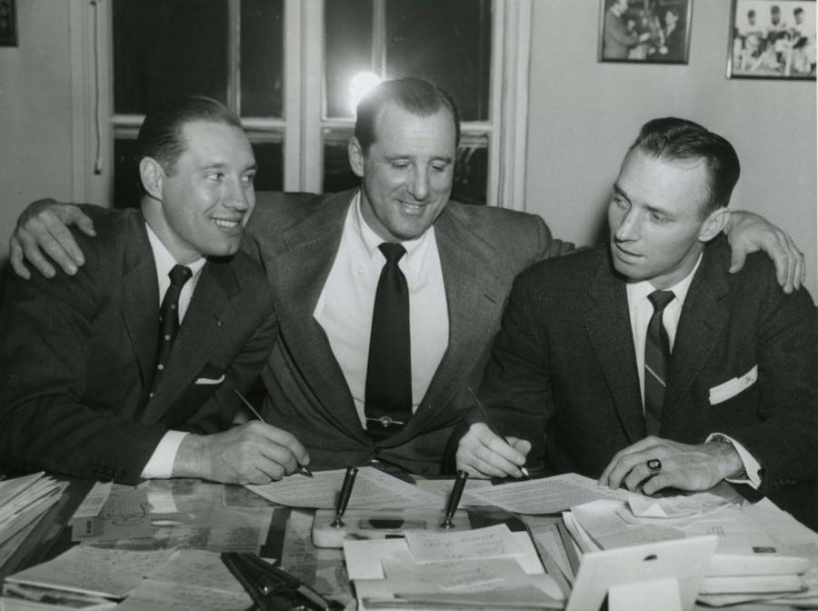 Indians pitcher Bob Feller (l) and catcher Jim Hegan (r) sit between GM Hank Greenberg as they sign their 1956 contracts - February 9, 1956