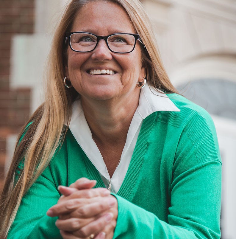 The image shows the candidate, Lori Camp lsmiling while looking off into the distance.