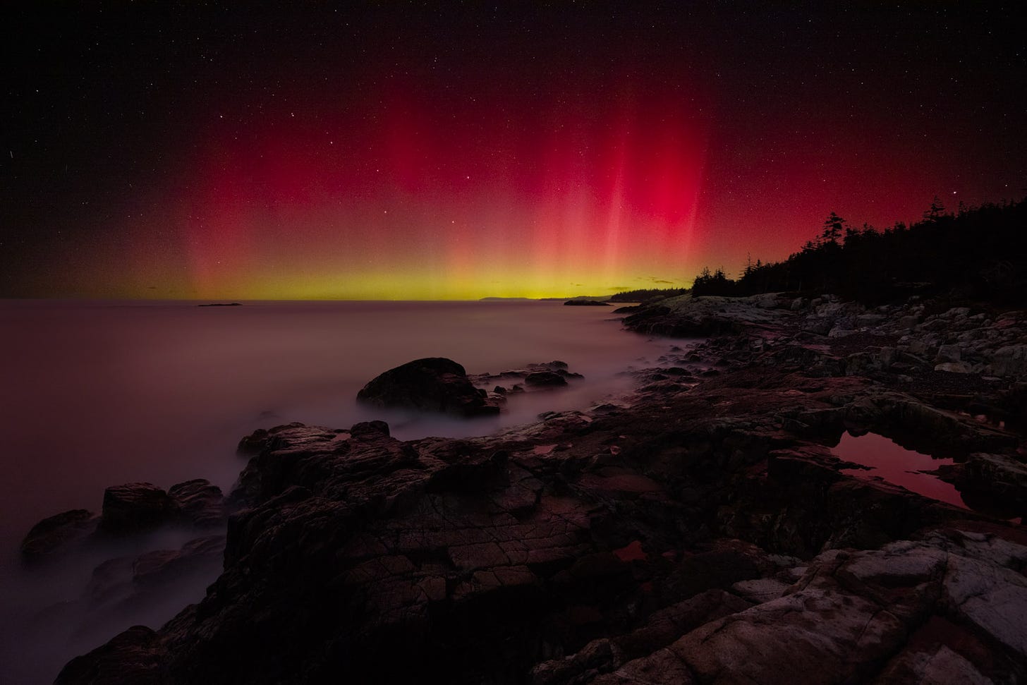 The Aurora Borealis, along with the Big Dipper, fill the horizon along the shores of Isle au Haut in Acadia National Park, Maine.