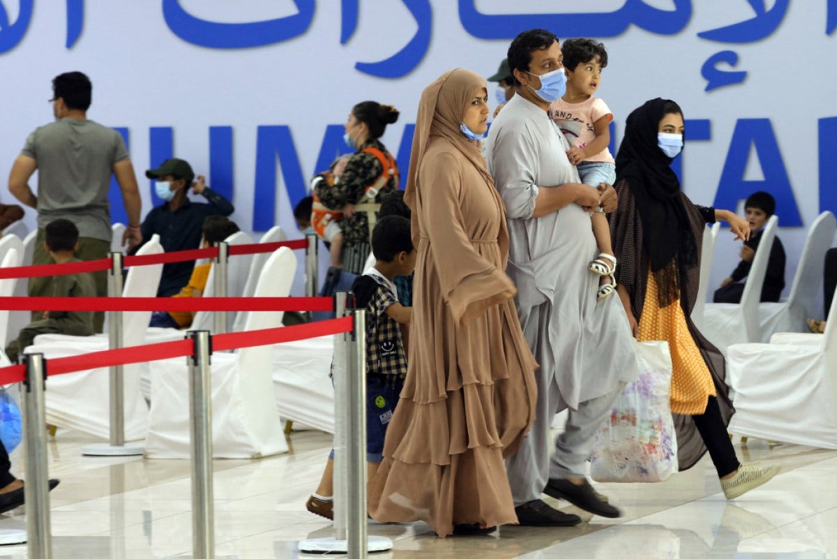 Refugees who fled Afghanistan after the takeover of their country by the Taliban, gather at the International Humanitarian City (IHC) in the Emirati capital Abu Dhabi, as they wait to be transferred to another destination, on August 28, 2021. (Photo by Giuseppe CACACE / AFP) (Photo by GIUSEPPE CACACE/AFP via Getty Images)
