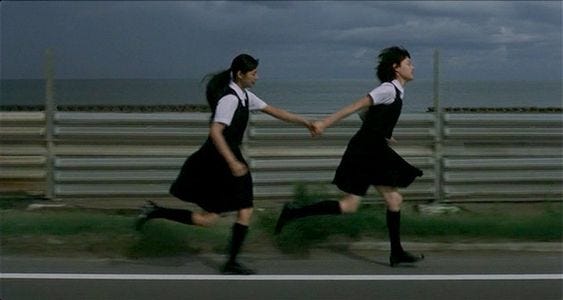 This may contain: two women in black and white dresses holding hands while running down the street with dark clouds behind them