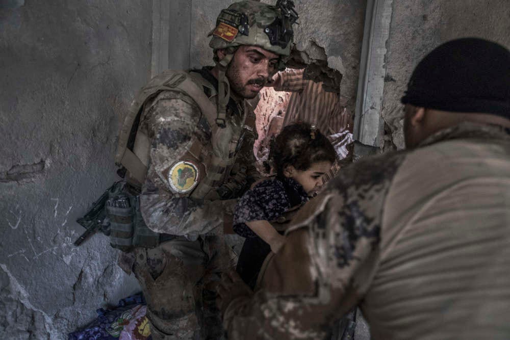 Des soldats des forces spéciales évacuent des enfants par une ouverture faite à la masse quelques minutes plus tôt.