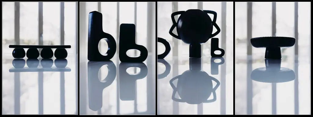 A line of black vases, all in different shapes.