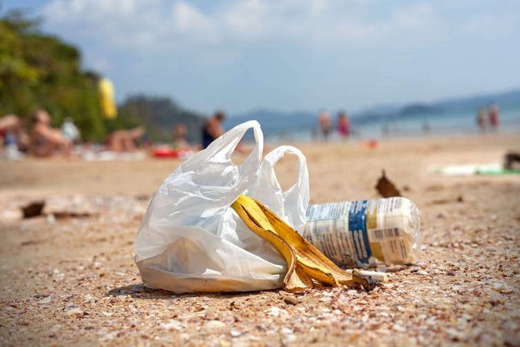 Plastic bag and plastic bottle left on beach