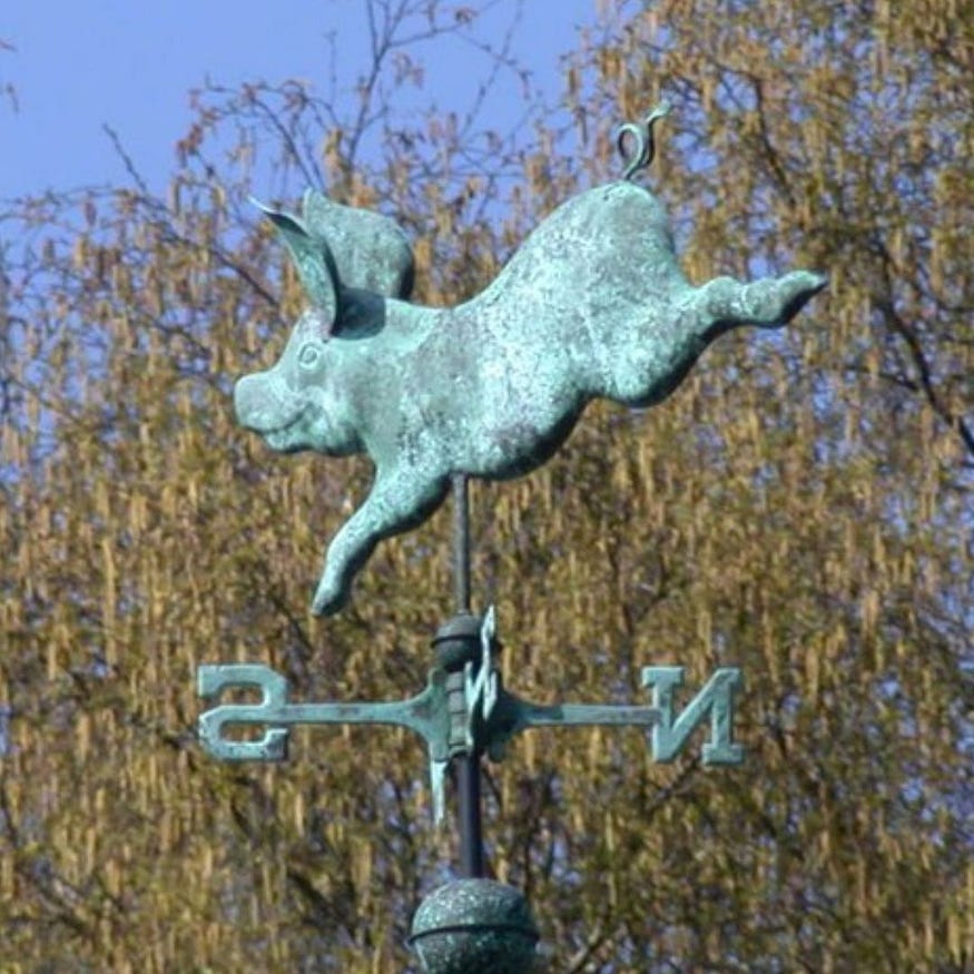 a weathered or faux weathered bronze or faux bronze likeness of me atop a weather vane against the leaves of a nearby treetop.