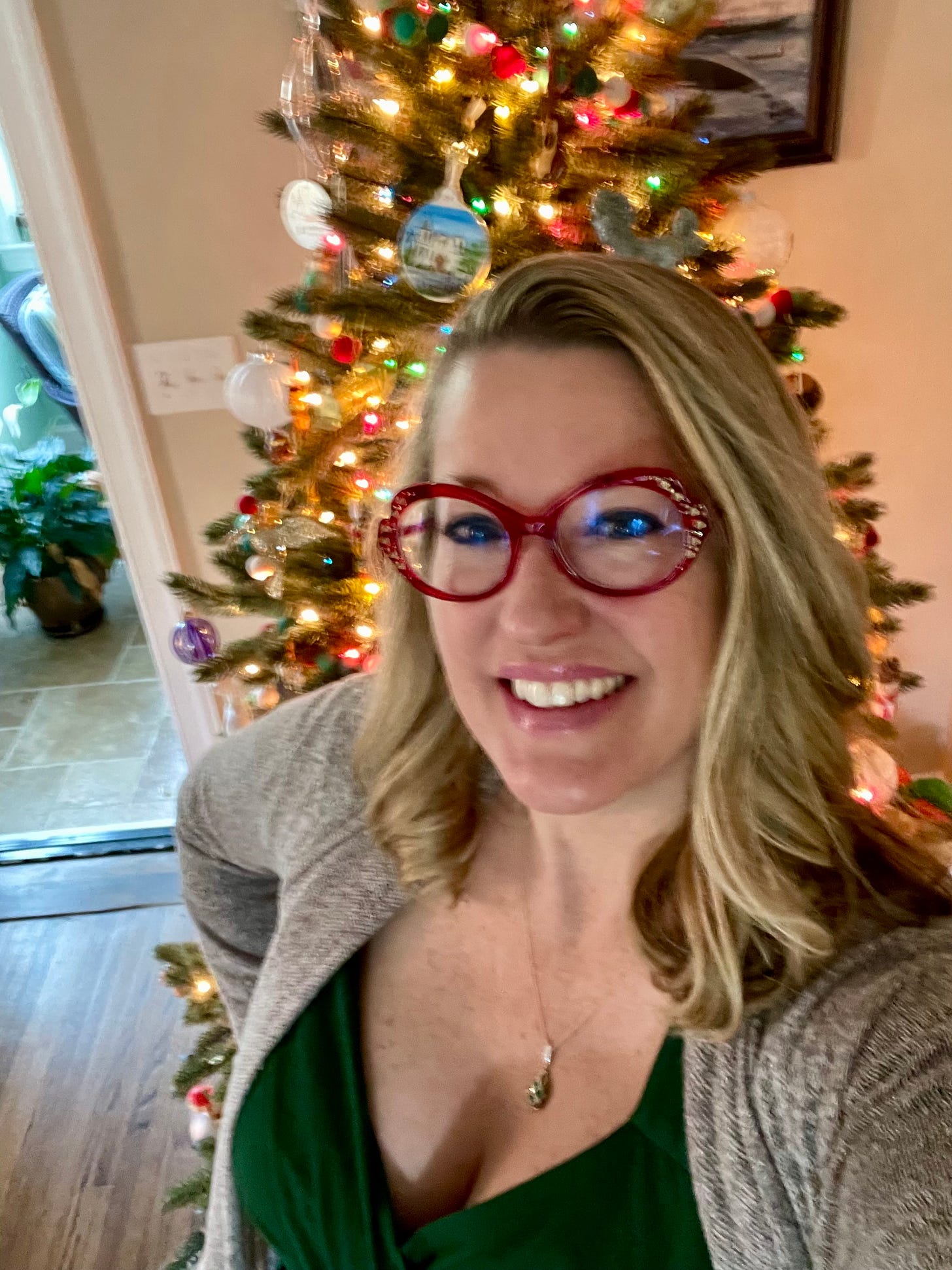 author Naomi Shibles in front of a Christmas tree