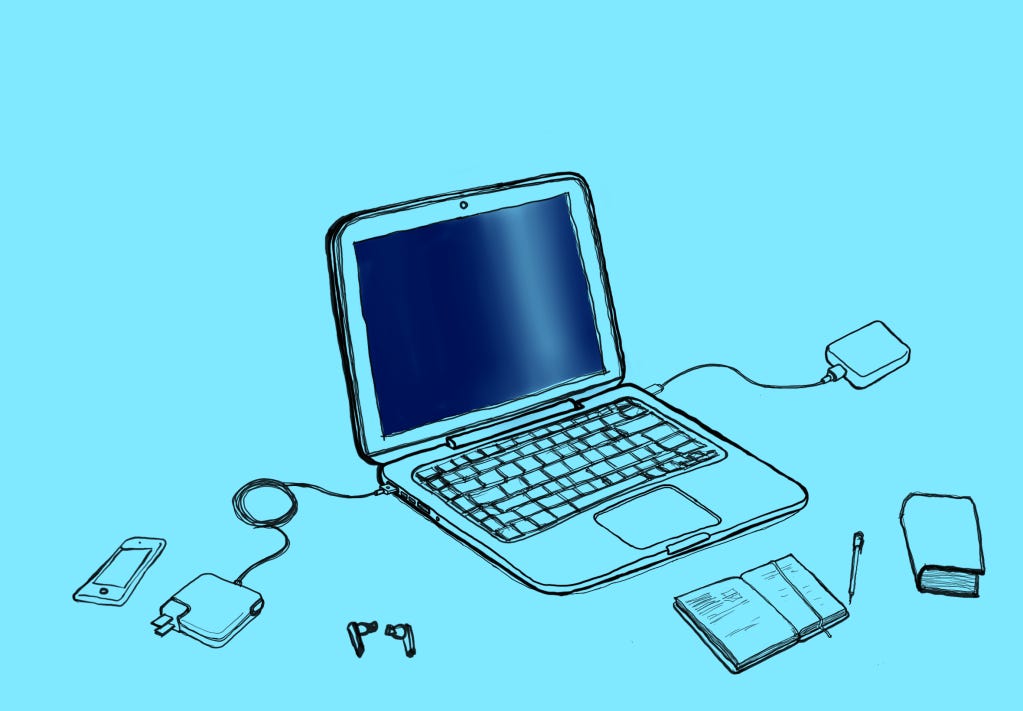 Um MacBook rodeado de acessórios e outros objetos