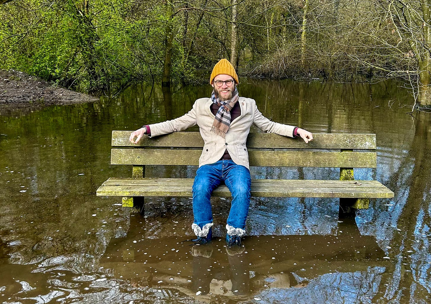 Adsum sitting on a bench, boot-deep in floodwater