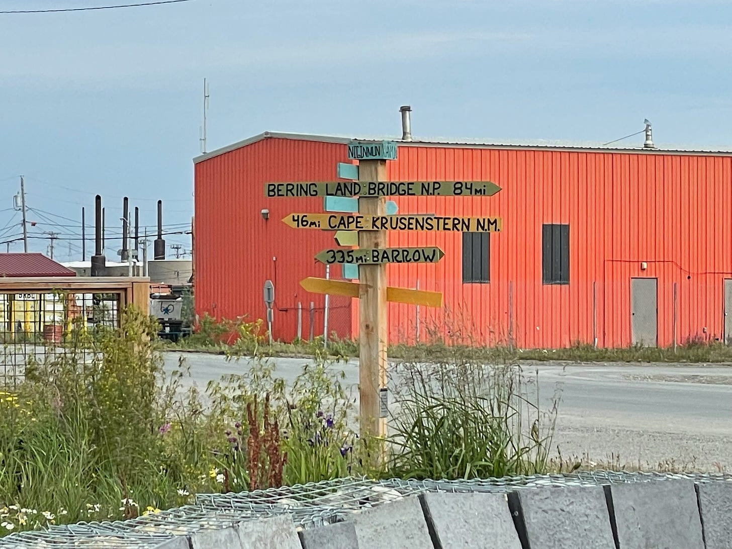 Sign in town of Kotzebue, Alaska showing distances to different cities.