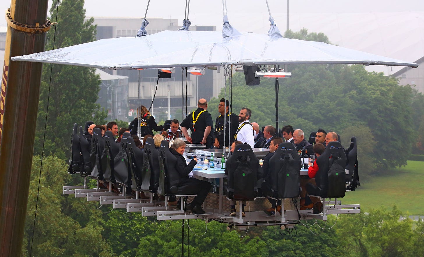 Diners sup at a dinner table suspended in the sky.