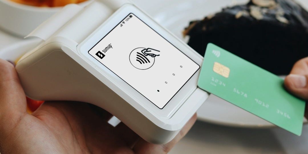 A person holding a credit card in front of a plate of food