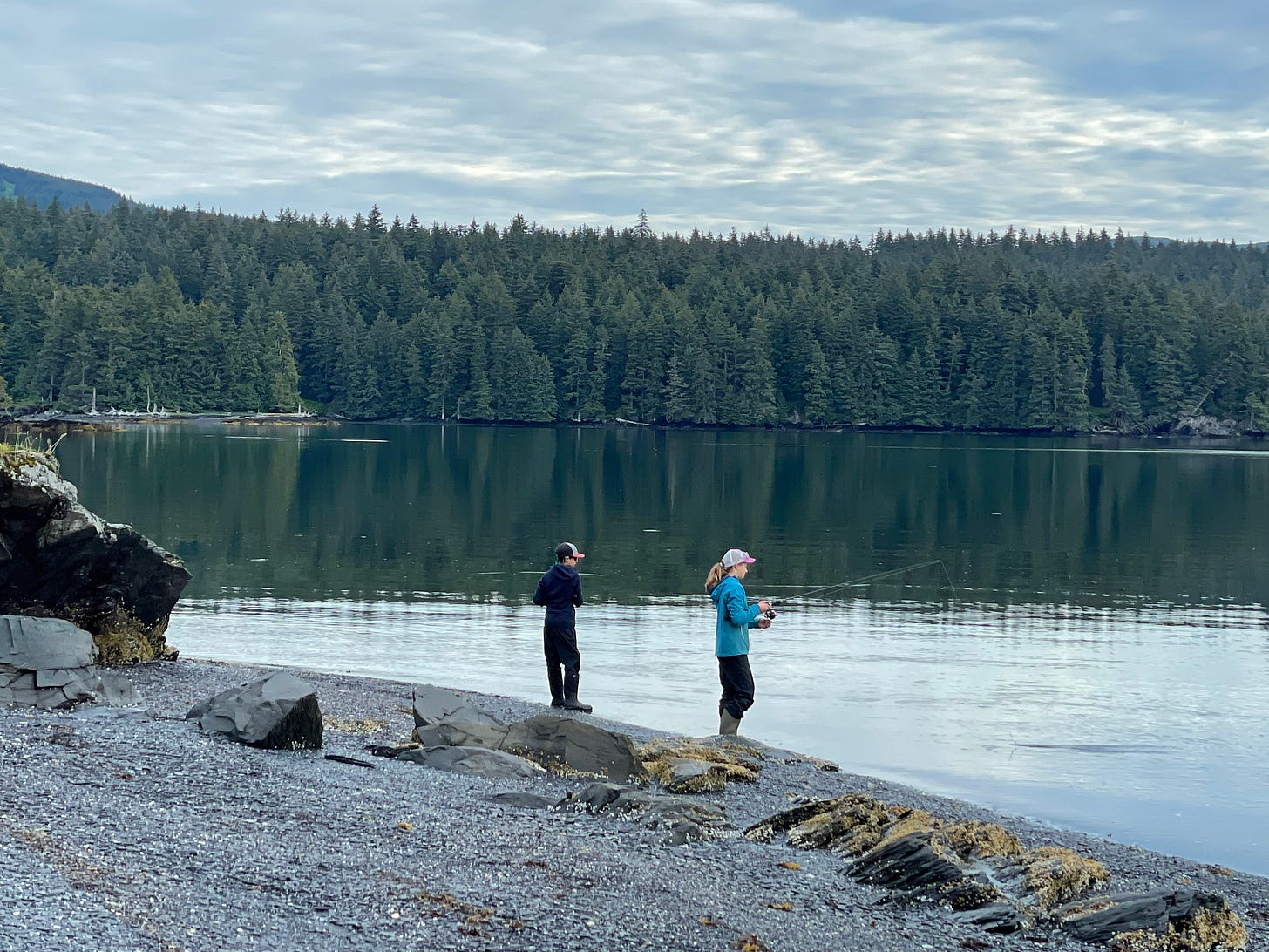 Two kids fishing from shore for salmon