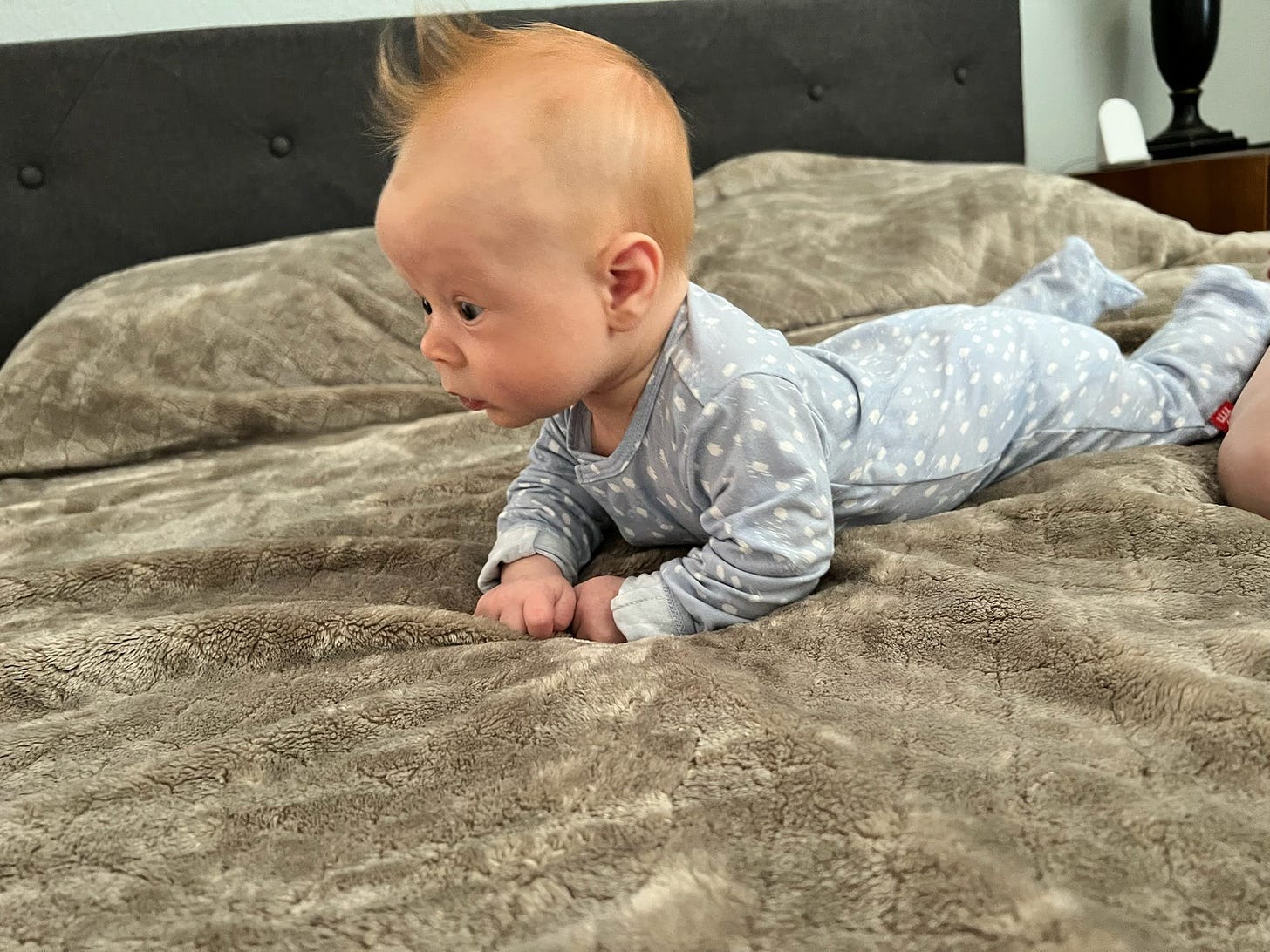 photo of Liam doing tummy time on my bed, with his head lifted high