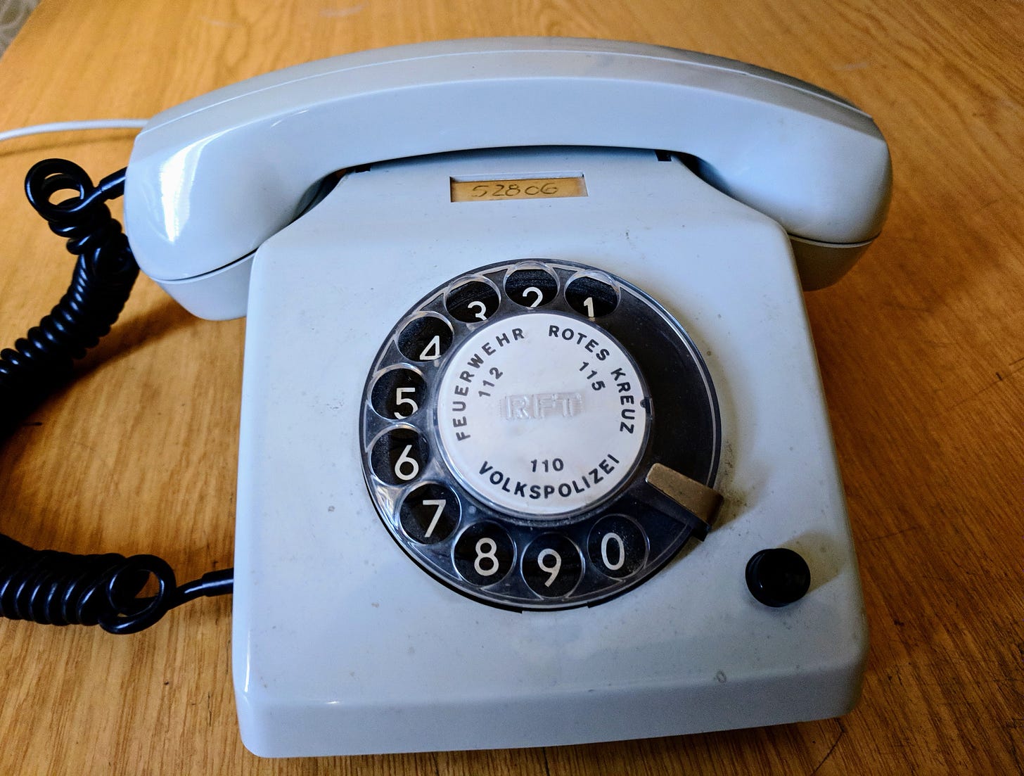 An old powder-blue rotary telephone, with numbers for the fire department, police, and Red Cross printed in German on the dialer