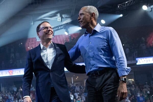 Barack Obama walks with his arm around Josh Shapiro. The two of them are smiling.