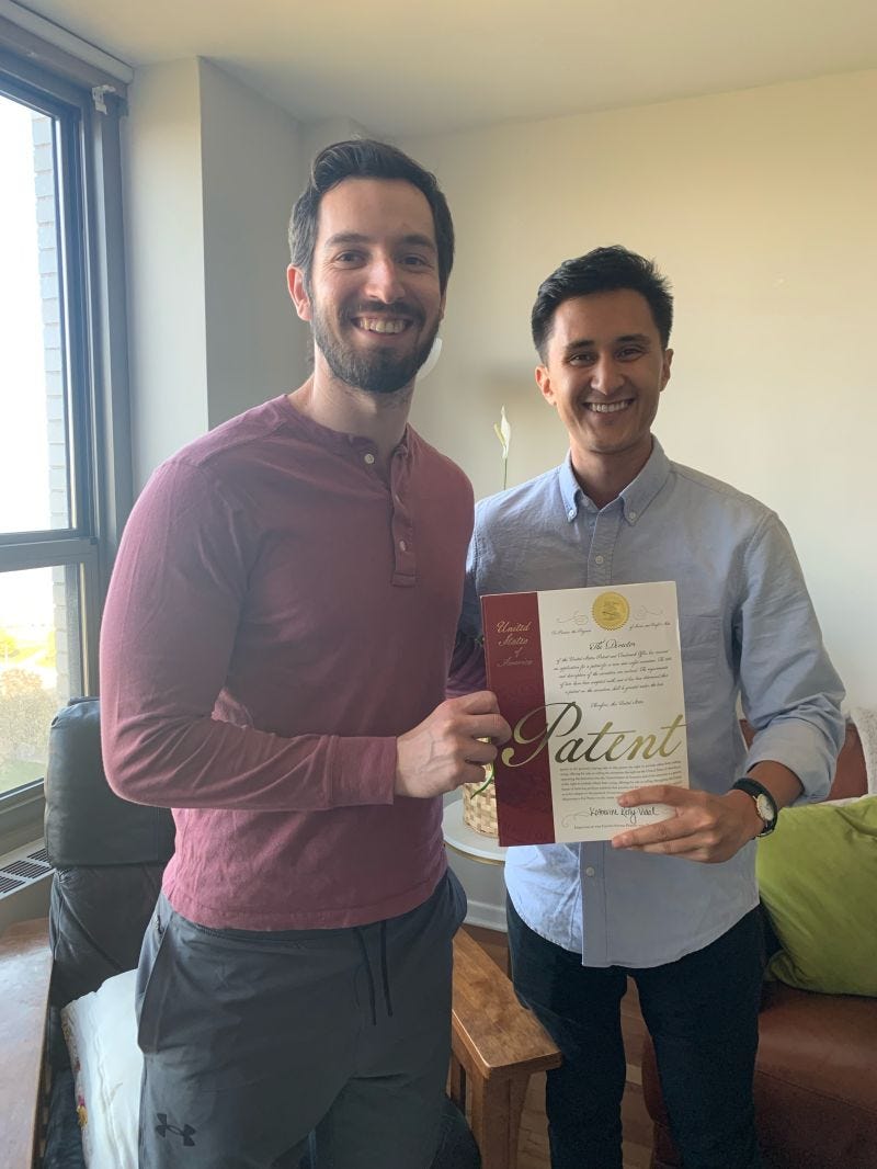 Co-founders of Kahana, Adam and Jonathan, smiling as they hold their first patent
