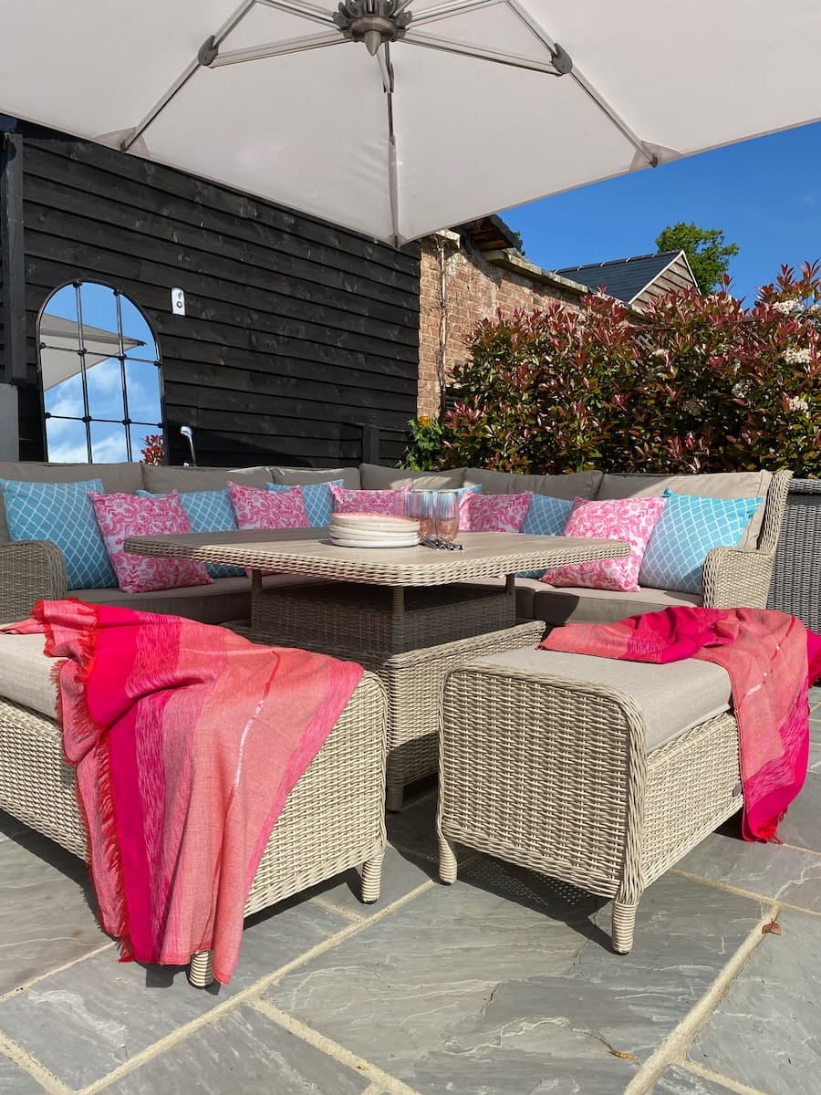 outdoor dining area with lots of bright coloured cushions applied to the seating