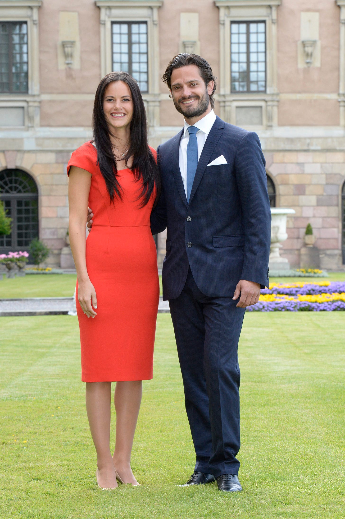 Sofia Helqvist and Prince Carl Philip pose in a red dress and suit