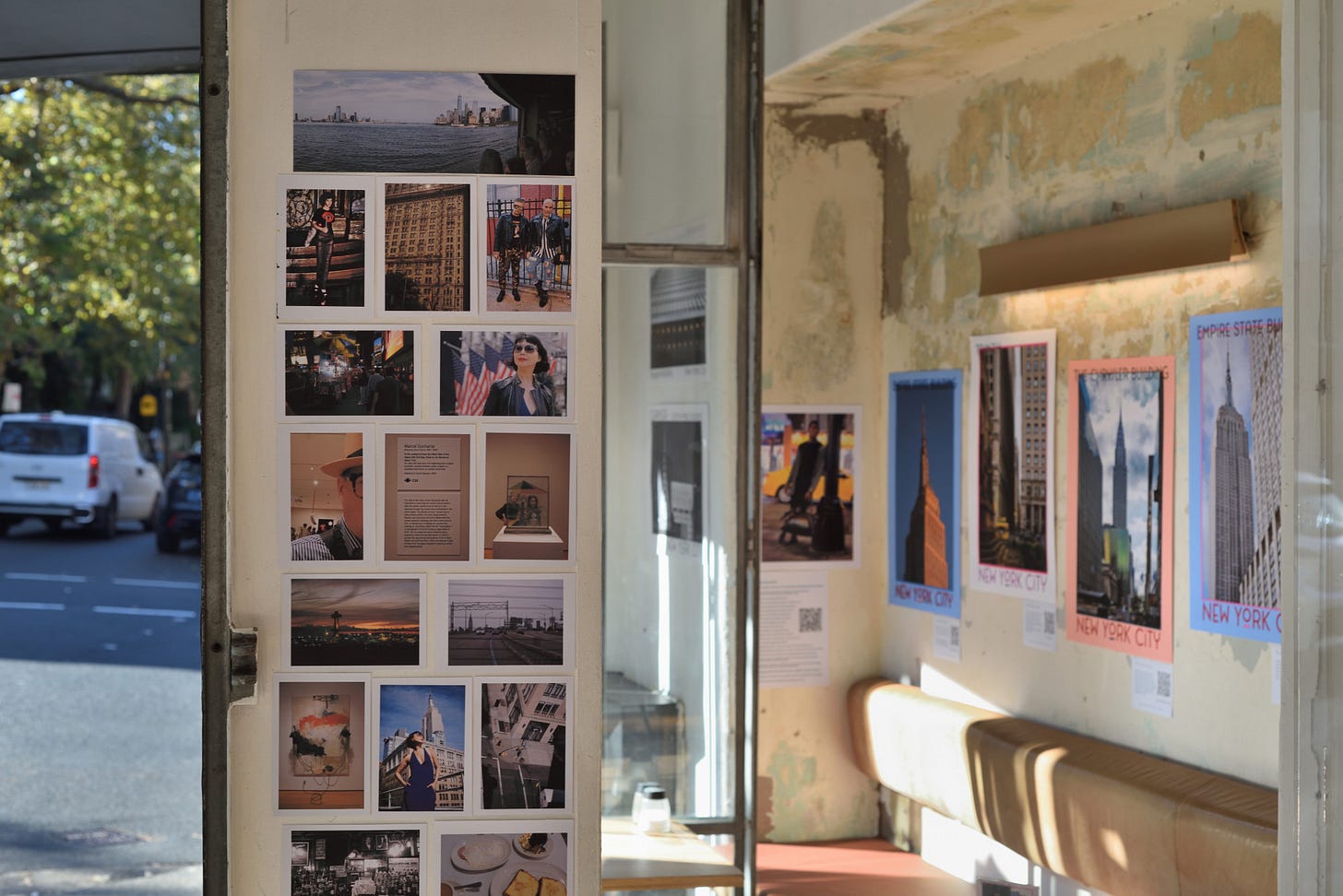 Mural of small prints, various pictures of New York City with the exhibition of skyscraper posters in the background.