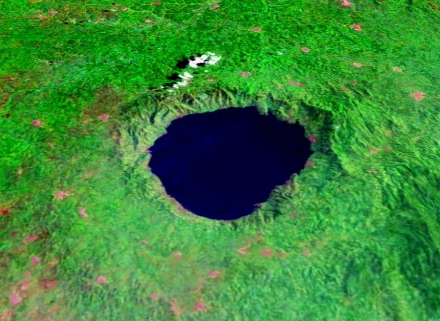 A satellite image of a round lake surrounded by a round ridge with green surrounding