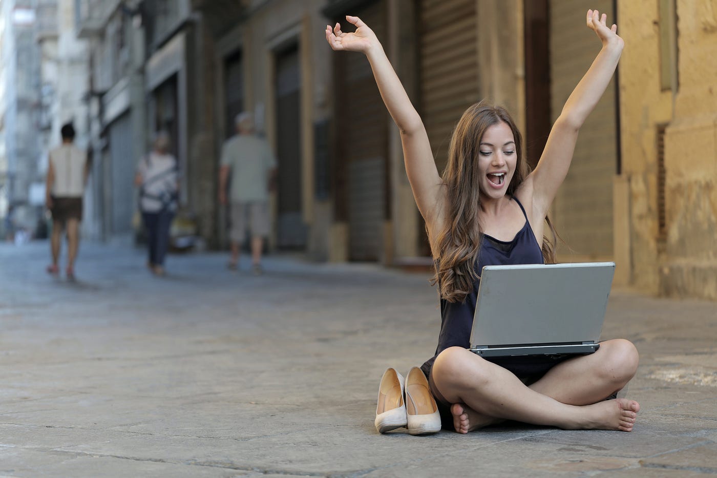 Person celebrating with raised arms, symbolizing the achievement of financial success through online writing.