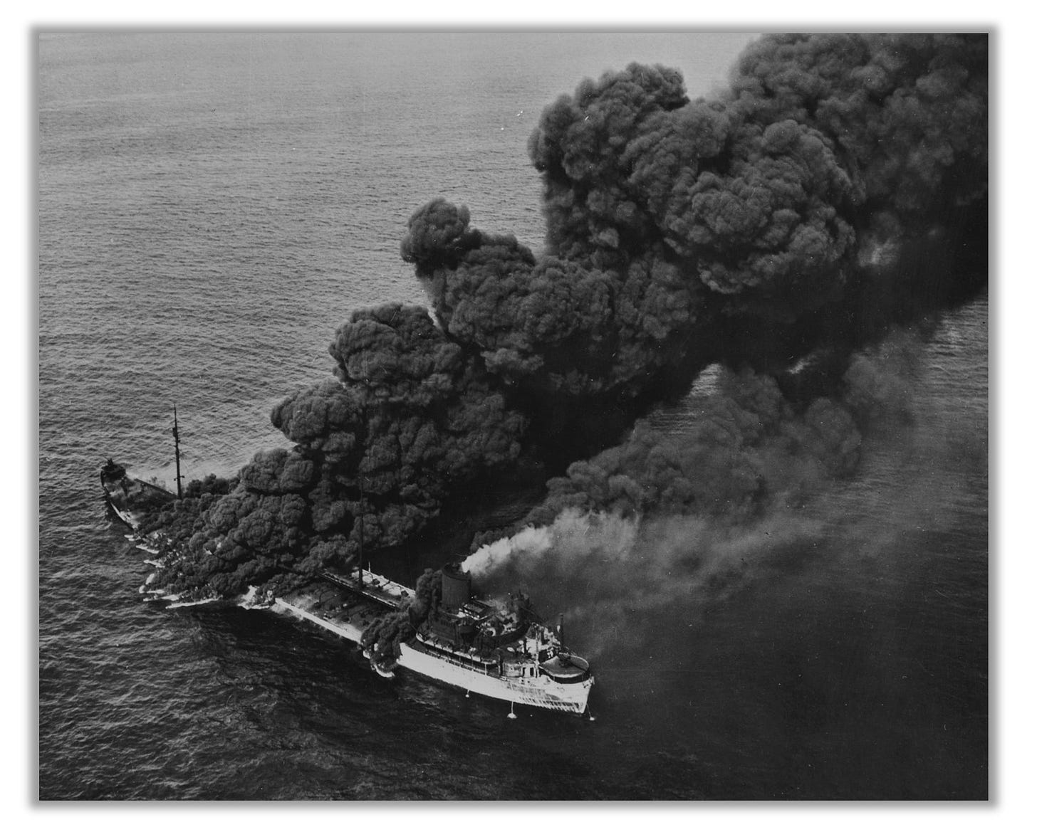 The tanker Pennsylvania Sun is pictured after it was torpedoed by U-571 on July 15, 1942.  Thick black smoke is pouring out of the vessel.