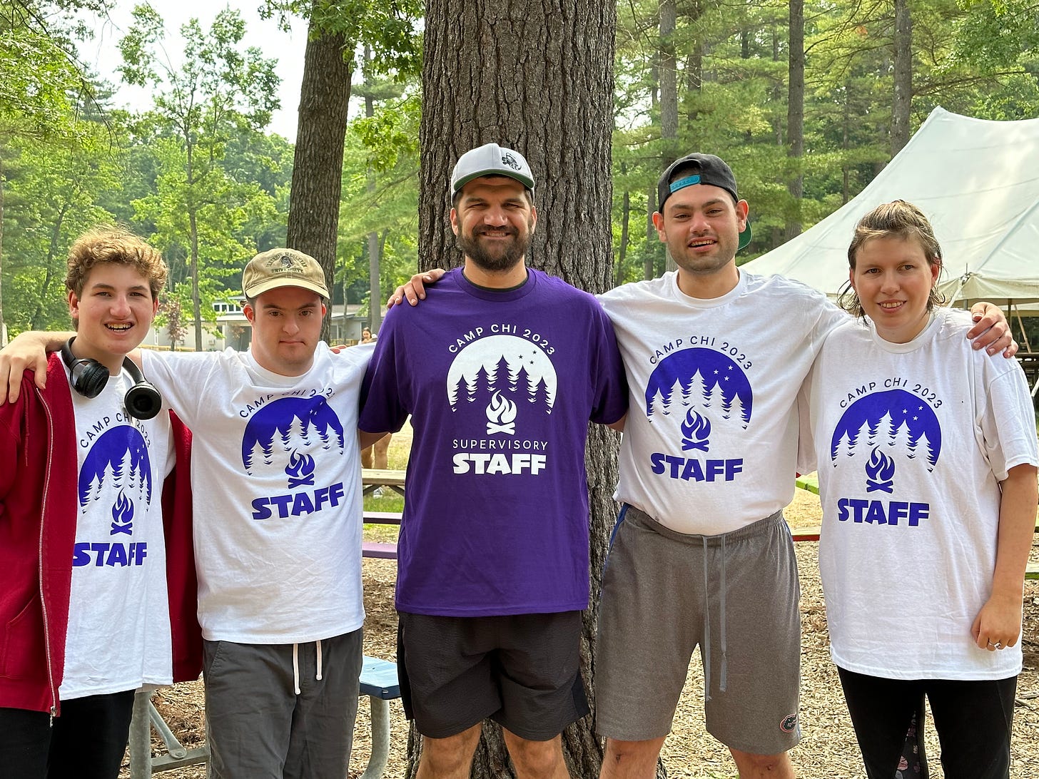 The four authors at Camp Chi with a Keshet staff person. they wear staff tshirts and stand in front of a large tree