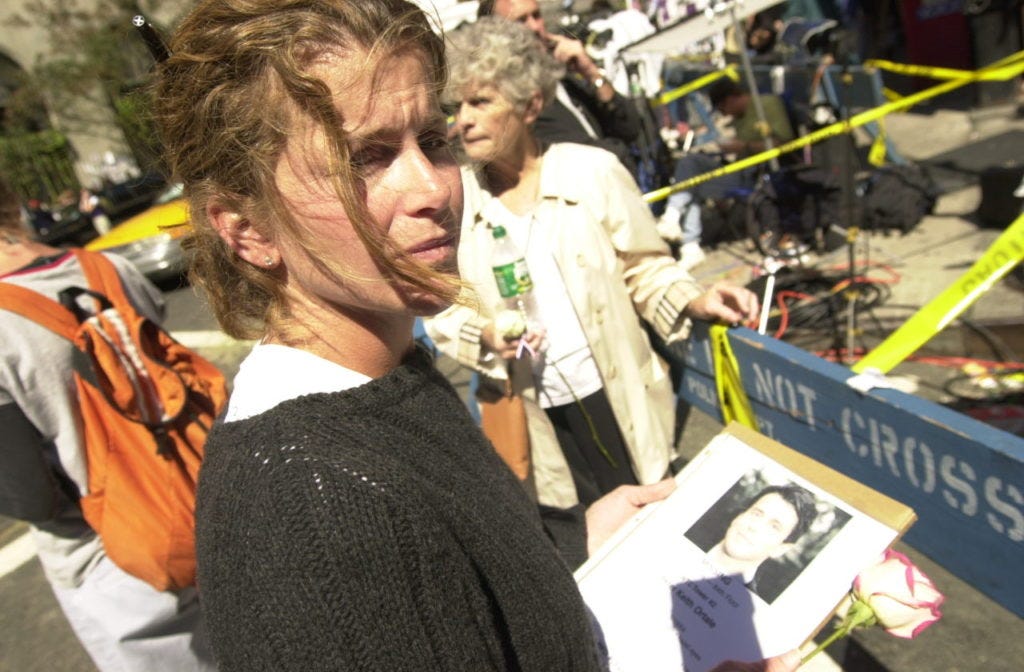 In this September 15, 2001 photograph, a woman poses with a picture of a missing loved one who was last seen at the World Trade Center when it was attacked on September 11, 2001.(AP Photo/Charlie Krupa)