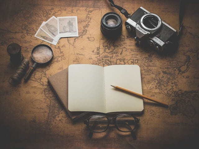 Pencil, notebook, camera, and map