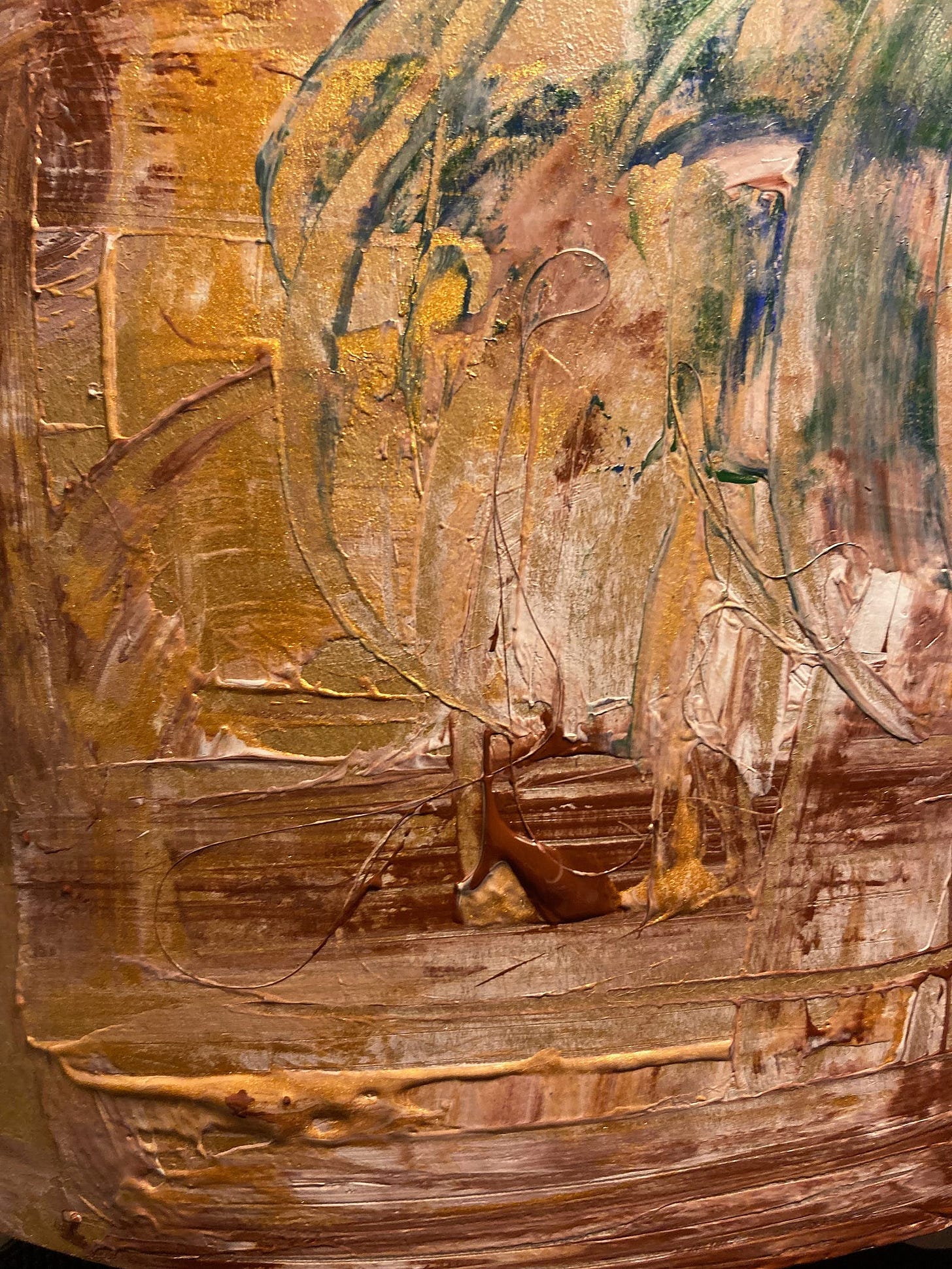 Abstract in acrylics — splurging of brown, beige and gold, with a hint of green foliage top right corner