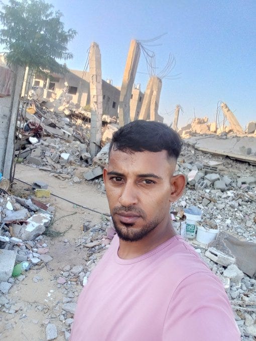 a Palestinian man stands in front of the rubble of a bombed neighbourhood