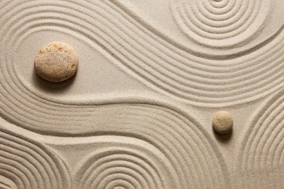 2 stones and rhythmic swirl patterns in a zen garden