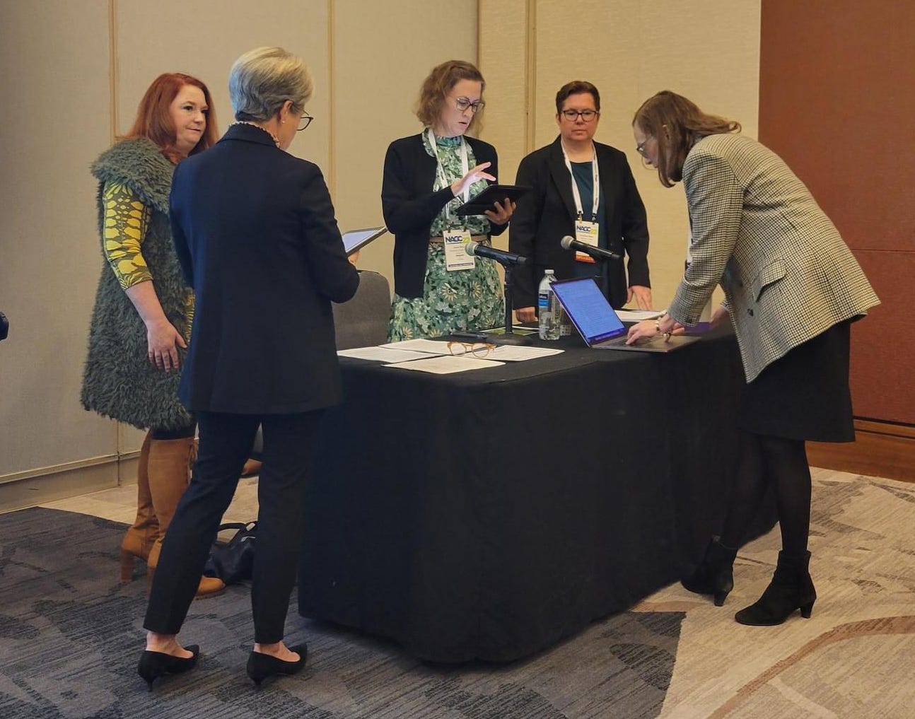 Image description: Erin Miller, Lauri Kirsch, Anne Rinn, Chris Wells, and Shelagh Gallagher stand around a table preparing for the OE session to begin. 