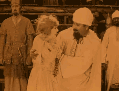 Animated gif from 1924 film The Seahawk - a Moorish slave trader displays a English woman taken captive