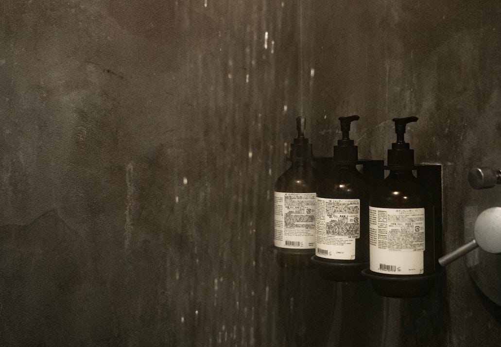 grayscale photo of bottles on wooden table