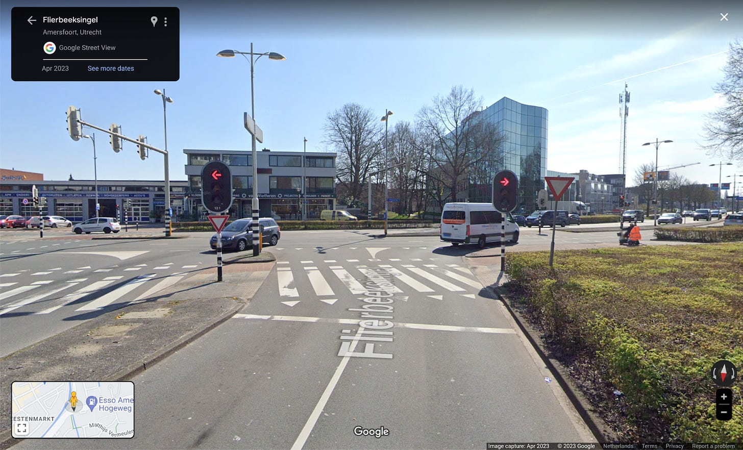 A streetview image of an intersection in the Netherlands, the perspective is in an approach lane about 20 meters back from the stopping line looking towards the intersection.